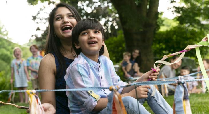 A mother and child with big smile surrounded by ribbon and string